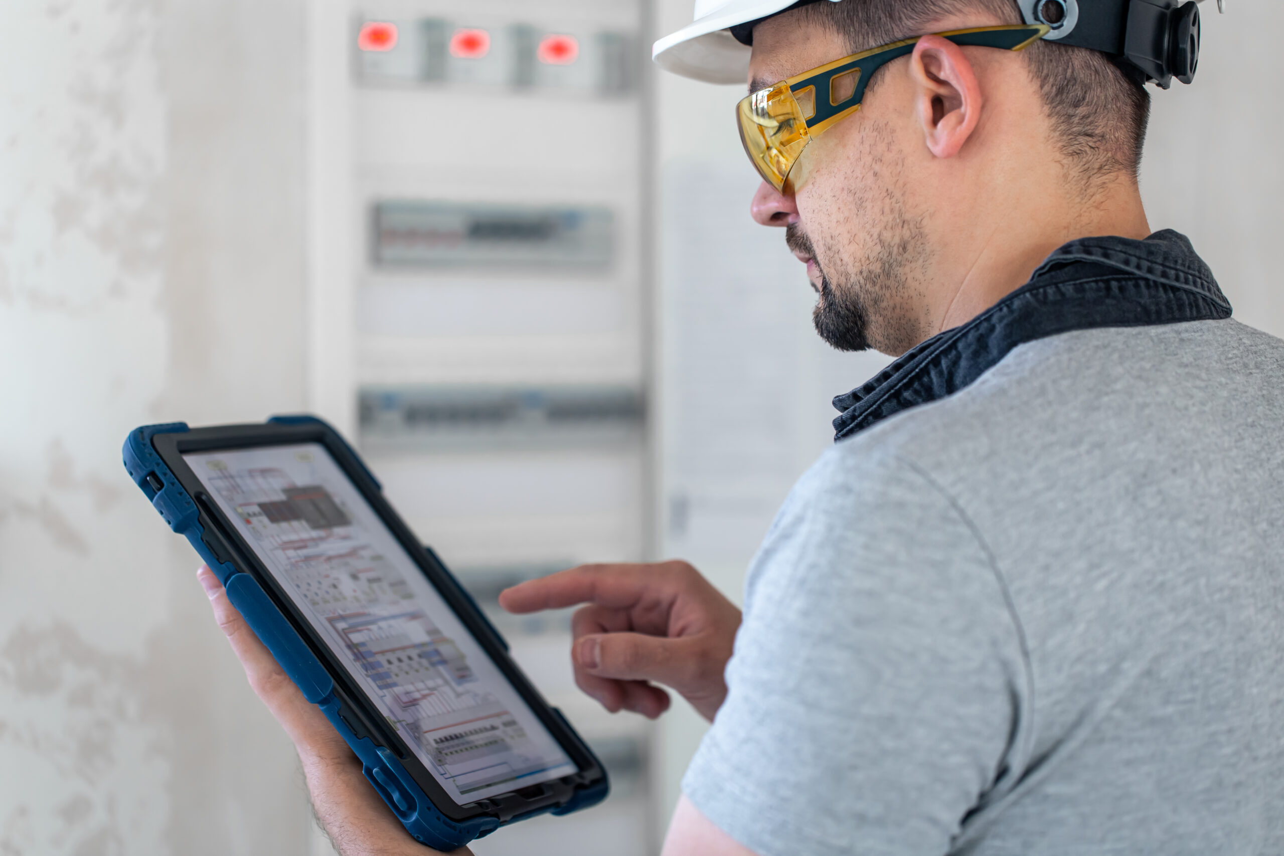 Electrical technician looking focused while working in a switchboard with fuses